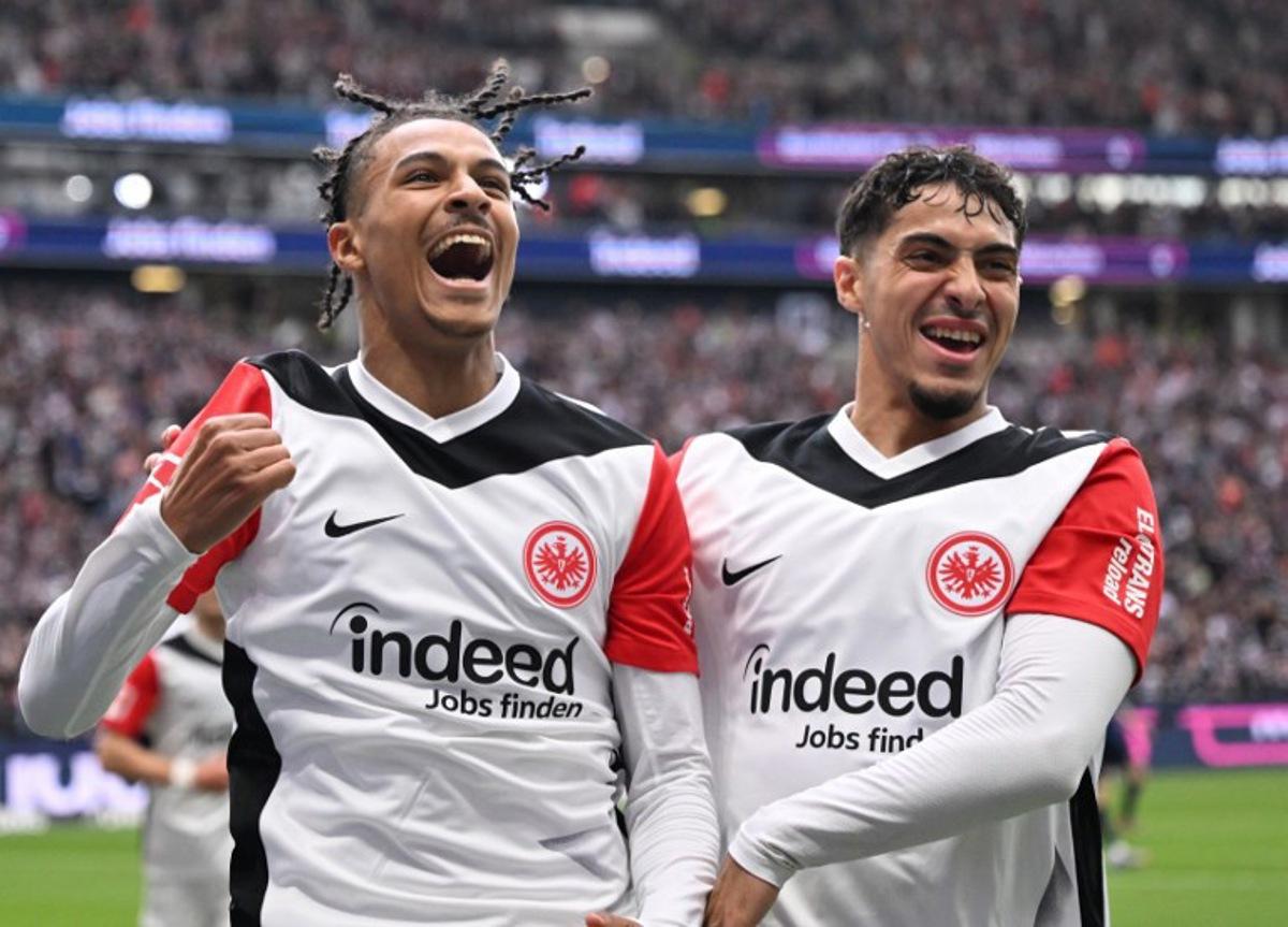 Frankfurt's French forward #19 Jean-Matteo Bahoya (L) celebrates with Frankfurt's Algerian midfielder #08 Fares Chaibi scoring during the German first division Bundesliga football match between Eintracht Frankfurt and Heidenheim in Frankfurt am Main, western Germany, on April 13, 2025.  Kirill KUDRYAVTSEV / AFP