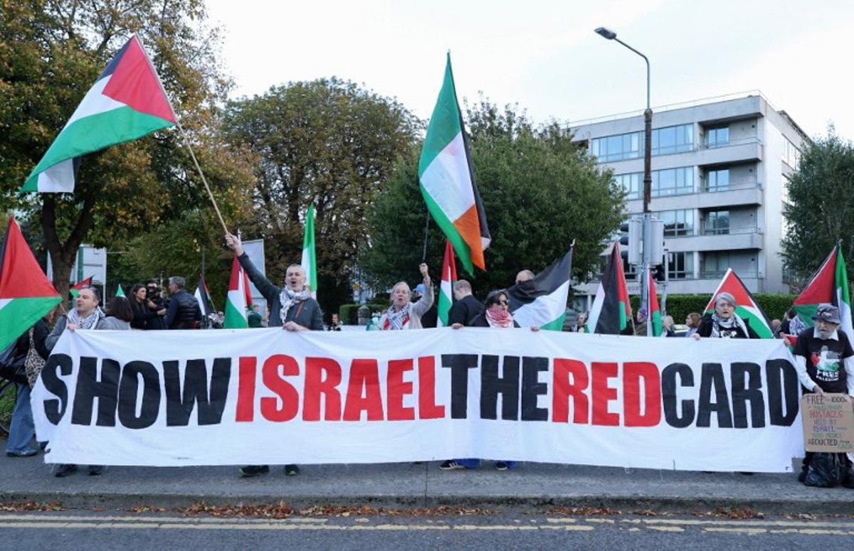 People hold placards calling on Ireland's football team not to play their next fixture against Israel, during a 'Stop The Game' protest outside Aviva Stadium in Dublin on October 1, 2026, ahead of the team's Nations League match against Austria.  Ireland coach Heimir Hallgrimsson said on September 30 they will play their second Nations League match against Israel on October 4 after the first fixture was thrown into doubt by player concerns over the Gaza war. Paul Faith / AFP