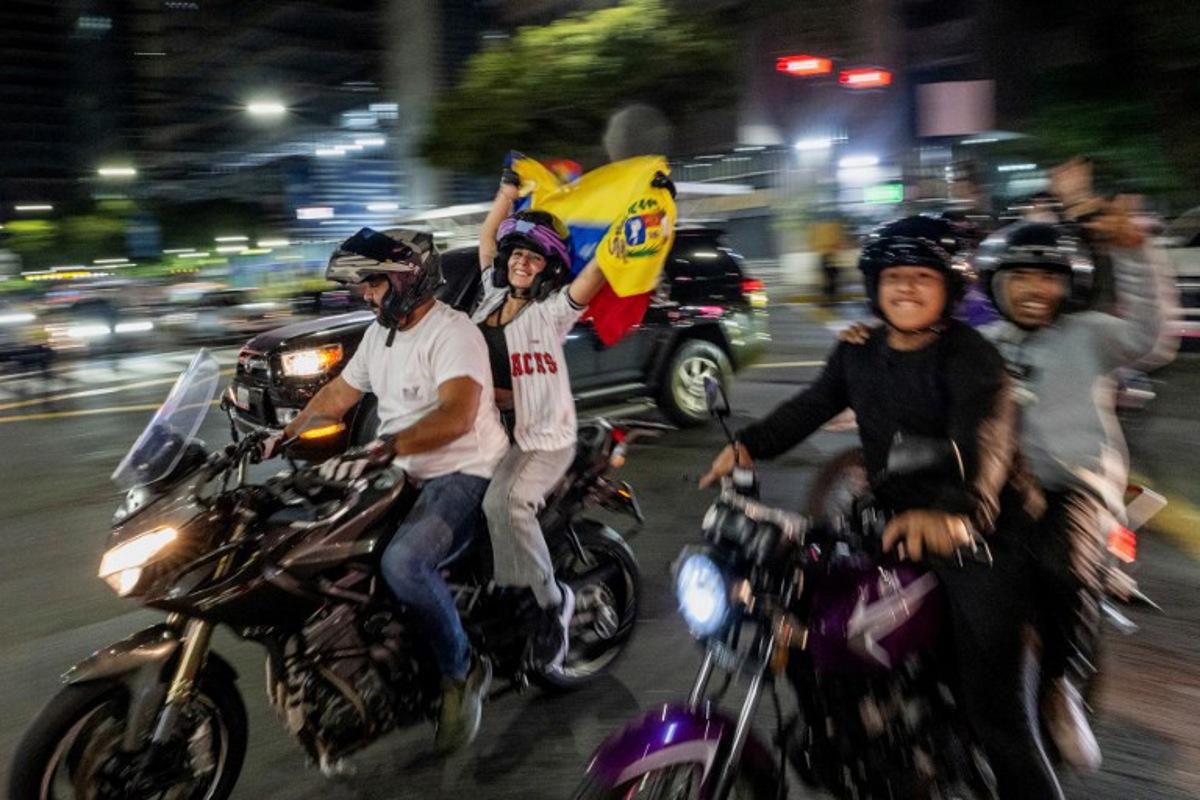 Venezuelan fans celebrate their national baseball team's victory in the final of the 2026 World Baseball Classic against the United States team, in Caracas on March 17, 2026. Venezuela, where baseball is the national sport, capped off its dream tournament by defeating the favorite, the United States, on home soil, amid tense relations between the two governments following the capture of President Nicolás Maduro by U.S. forces in January. Juan BARRETO / AFP