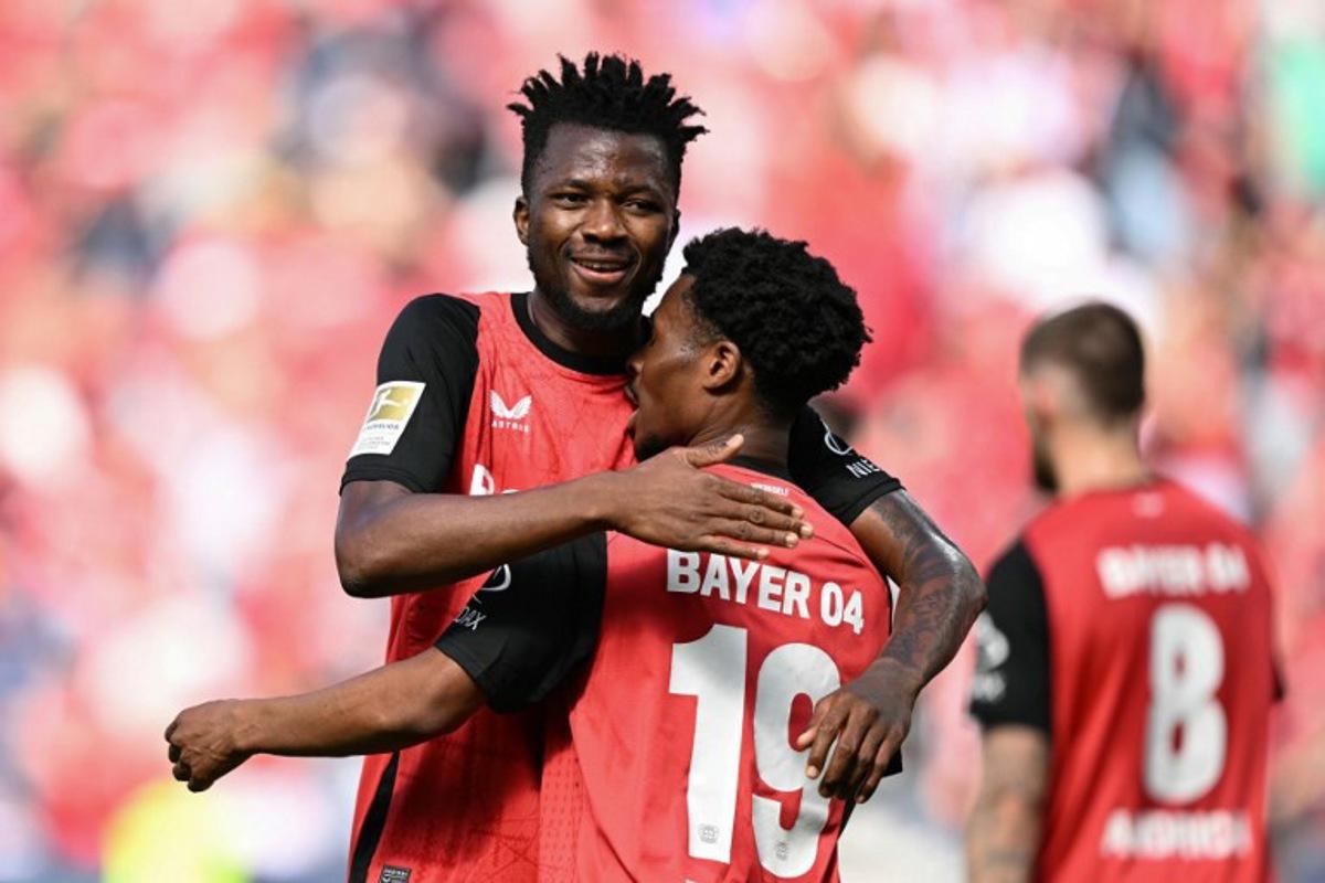 Bayer Leverkusen's English midfielder #19 Nathan Tella (front) celebrates the opening goal with team mate Bayer Leverkusen's Nigerian forward #22 Victor Boniface during the German first division Bundesliga football match between Bayer 04 Leverkusen and FC Augsburg in Leverkusen, western Germany on April 26, 2025.  INA FASSBENDER / AFP