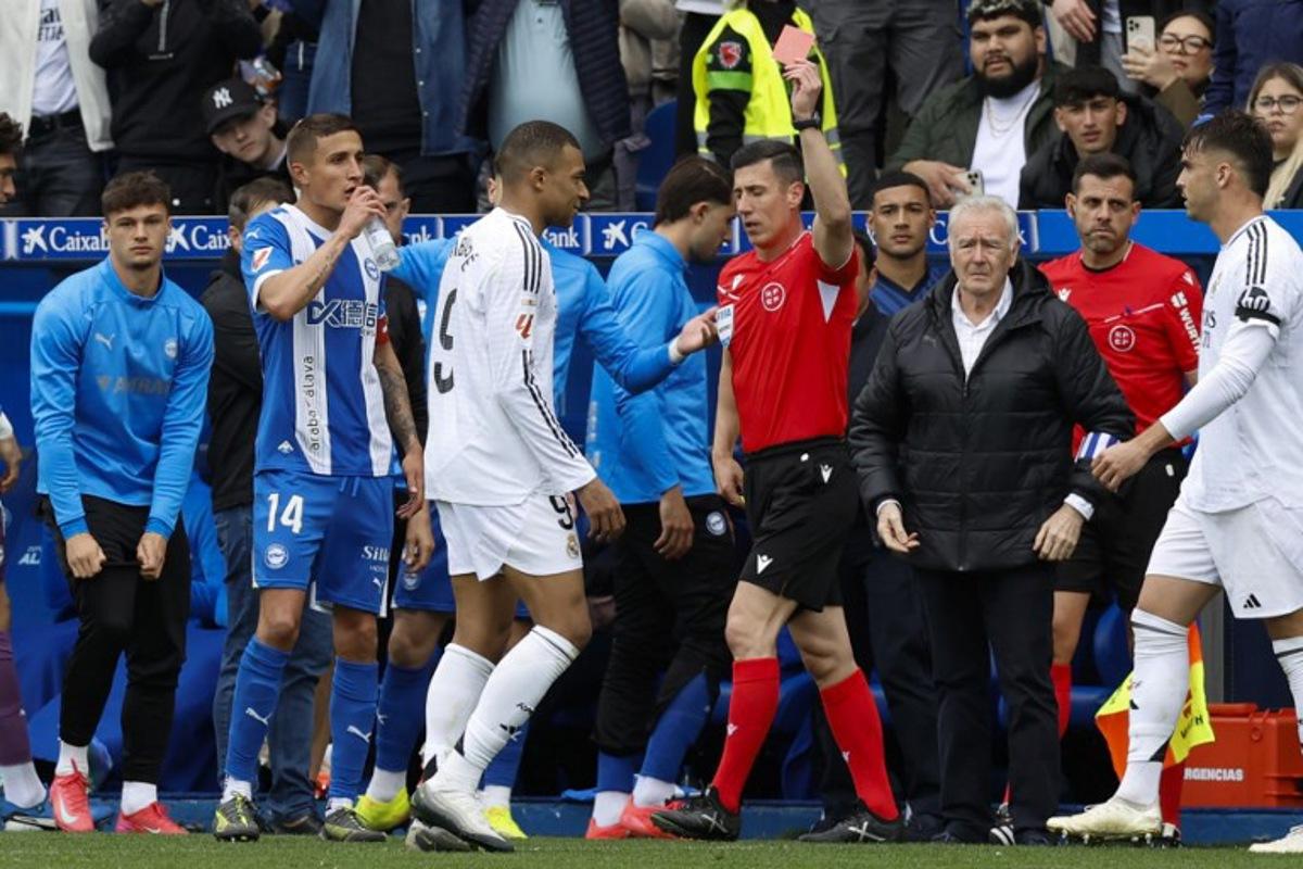 Real Madrid's French forward #09 Kylian Mbappe receives a red card from referee Cesar Soto during the Spanish league football match between Deportivo Alaves and Real Madrid CF at the Mendizorroza stadium in Vitoria on April 13, 2025.  Ander GILLENEA / AFP