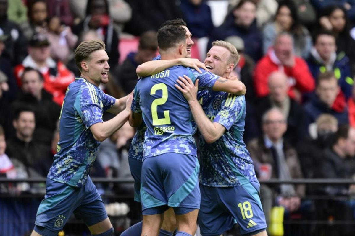 Ajax's Dutch midfielder #18 Davy Klaassen (R) celebrates with teammates Ajax's Dutch midfielder #08 Kenneth Taylor (L) and Ajax's Brazilian defender #02 Luca Rosa (C) after scoring the opening goal during the Dutch Eredivisie fooball match between PSV Eindhoven and Ajax Amsterdam at the Phillips Stadium in Eindhoven on March 30, 2025.  Olaf Kraak / ANP / AFP