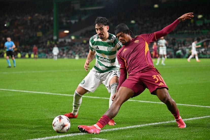 Celtic's Tunisian striker #23 Sebastian Tounekti (L) battles with Roma's Jamaican forward #31 Leon Bailey (R) during the UEFA Europa League league stage football match between Celtic and Roma at Celtic Park in Glasgow on December 11, 2025.  ANDY BUCHANAN / AFP