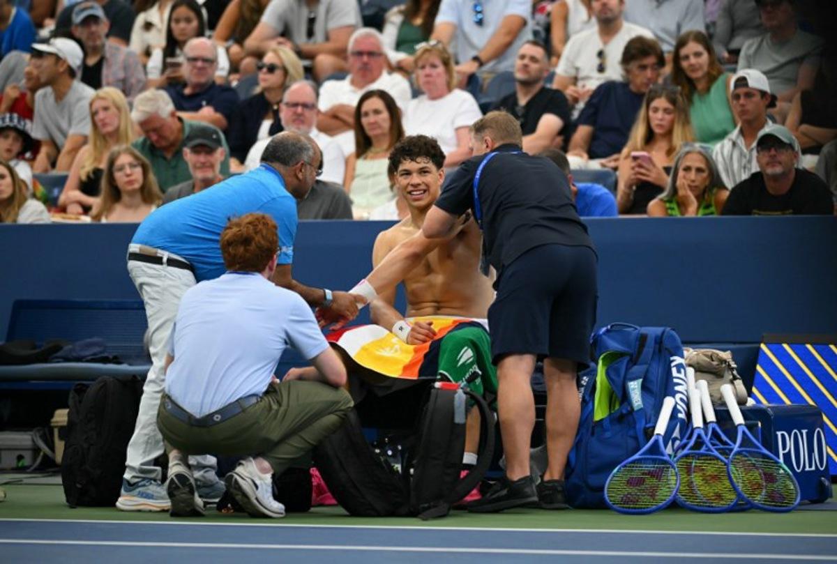 USA's Ben Shelton receives medical attention as he plays France's Adrian Mannarino during their men's singles third round match on day six of the US Open tennis tournament at the USTA Billie Jean King National Tennis Center in New York City on August 29, 2025.  ANGELA WEISS / AFP