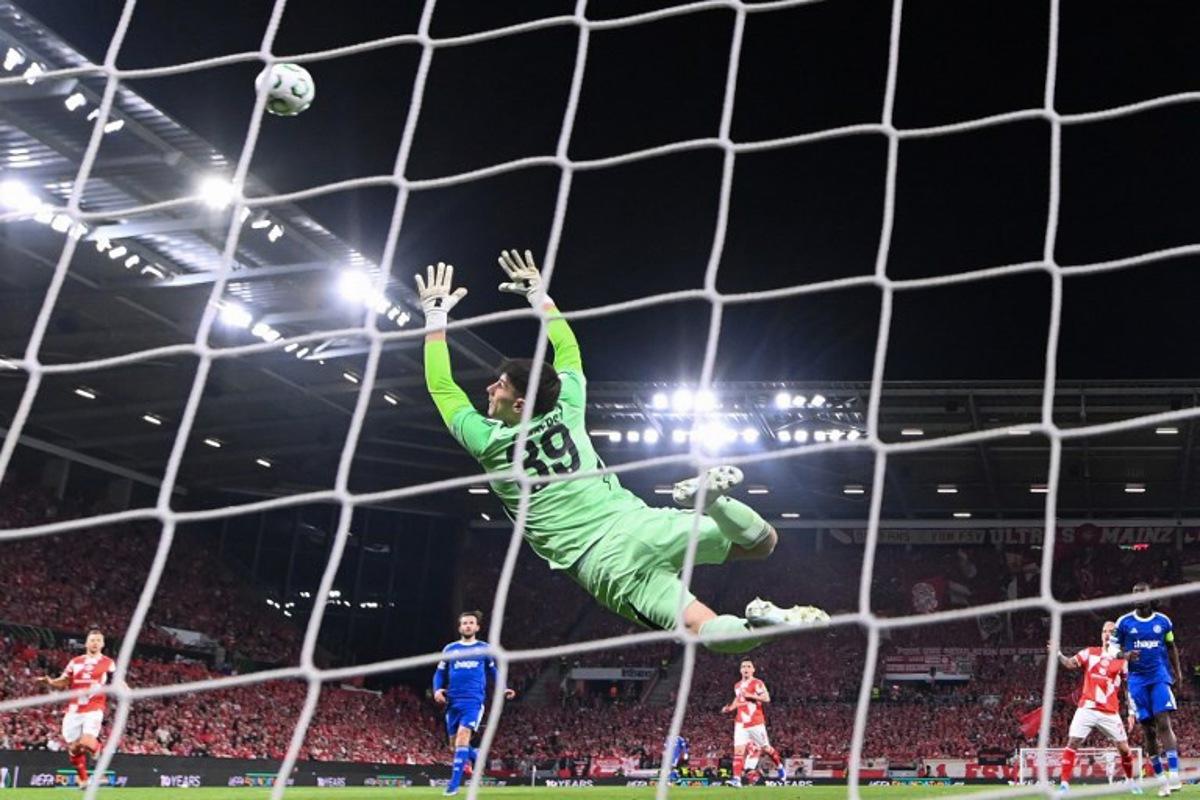 Strasbourg's Belgian goalkeeper #39 Mike Penders (L) fails to save the first goal by Mainz' Japanese midfielder #06 Kaishu Sano (not pictured) during the UEFA Europa Conference League quarter-final first leg football match between 1 FSV Mainz 05 and RC Strasbourg Alsace in Mainz, western Germany on April 9, 2026.  Kirill KUDRYAVTSEV / AFP