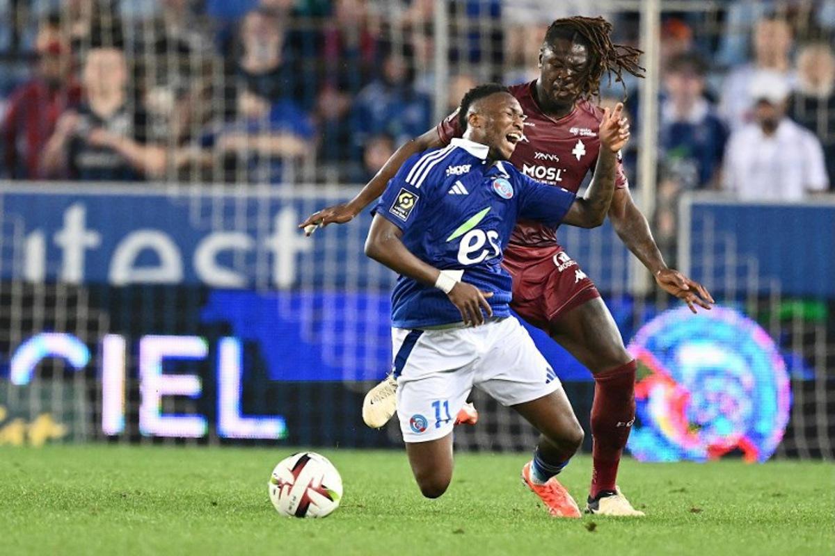 Strasbourg's Ivorian Malian forward #11 Moise Sahi Dion is tackled by Metz's French midfielder #06 Kevin N'Doram during the French L1 football match between RC Strasbourg Alsace and FC Metz at the Stade de la Meinau in Strasbourg, eastern France, on May 12, 2024.   SEBASTIEN BOZON / AFP