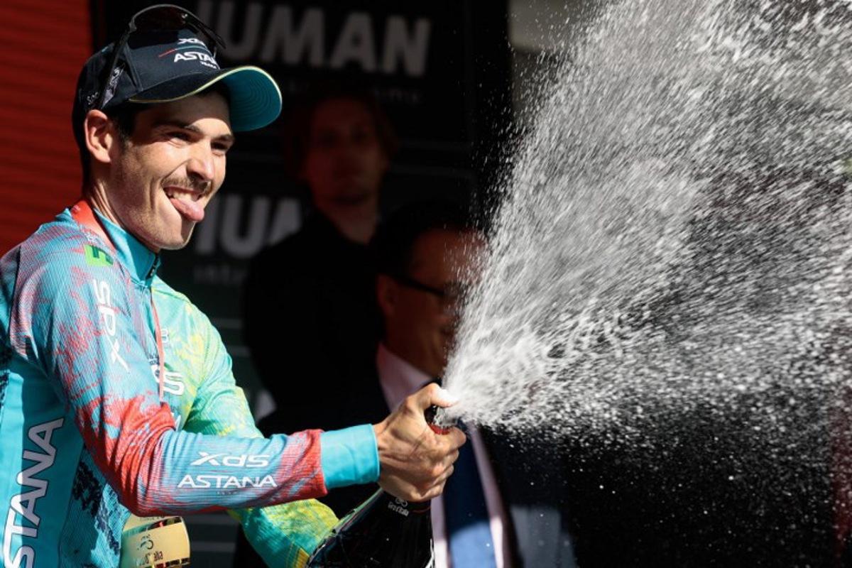 XDS Astana Team's Italian rider Christian Scaroni sprays champagne as he celebrates on the podium after victory in the 16th stage of the 108th Giro d'Italia cycling race of 203kms from Piazzola sul Brenta to San Valentino on May 27, 2025.  Luca Bettini / AFP