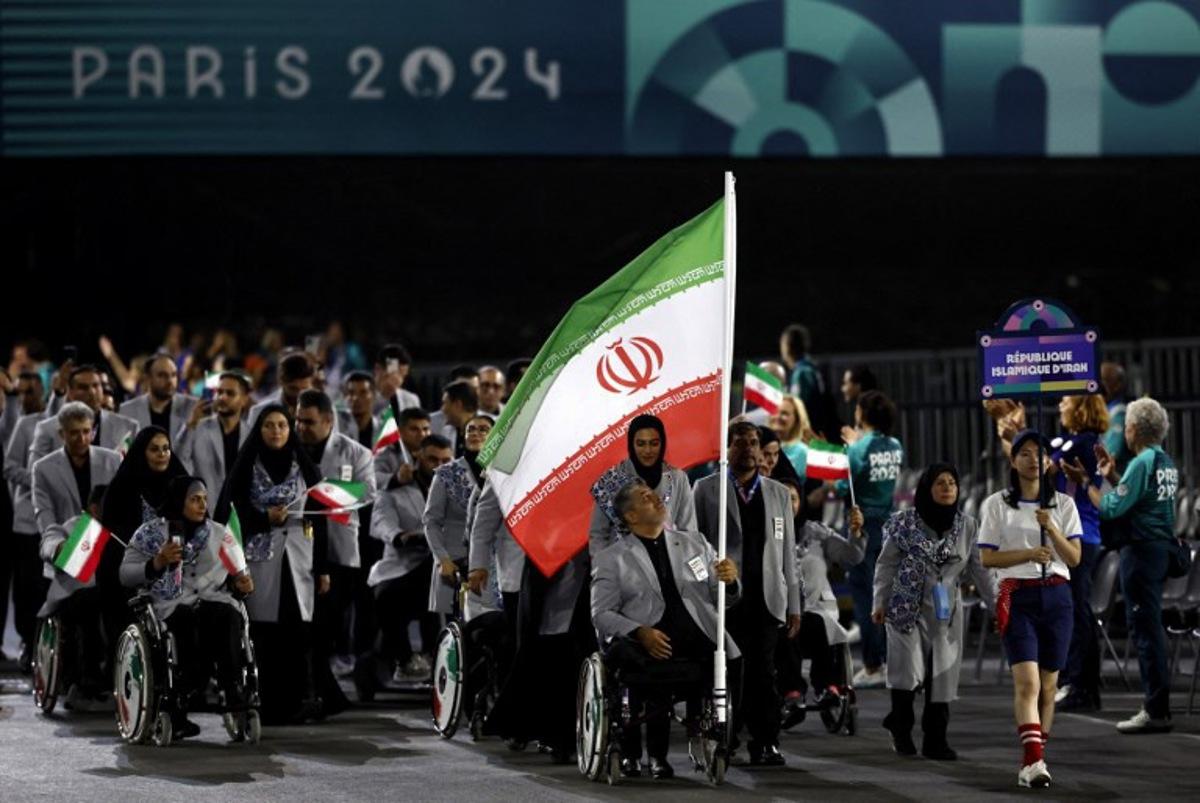 Iran's flagbearers and Paralympic athletes Seyed Mohammadreza Mirshafiei and Hajar Safarzadeh Ghahderijani parade during the Paris 2024 Paralympic Games Opening Ceremony in Paris on August 28, 2024.  Gonzalo Fuentes / POOL / AFP