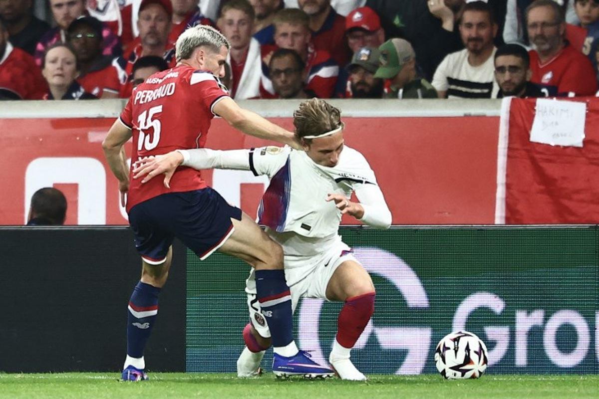 PSG's Belgian forward #22 Mika Godts (R) and Lille's French defender #15 Romain Perraud fight for the ball during the French L1 football match between Lille LOSC and Paris Saint-Germain (PSG) at the Stade Pierre-Mauroy in Villeneuve-d'Ascq, northern France, on August 28, 2026.  Sameer AL-DOUMY / AFP