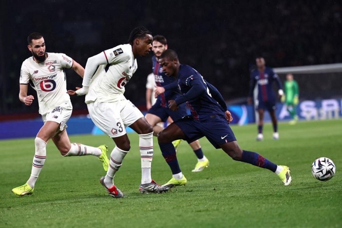 Paris Saint-Germain's Portuguese defender #25 Nuno Mendes (R) and Lille's Belgian defender #03 Nathan Ngoy (2L) fight for the ball during the French L1 football match between Paris Saint-Germain (PSG) and Lille LOSC at the Parc des Princes stadium in Paris on January 16, 2026.  Anne-Christine POUJOULAT / AFP