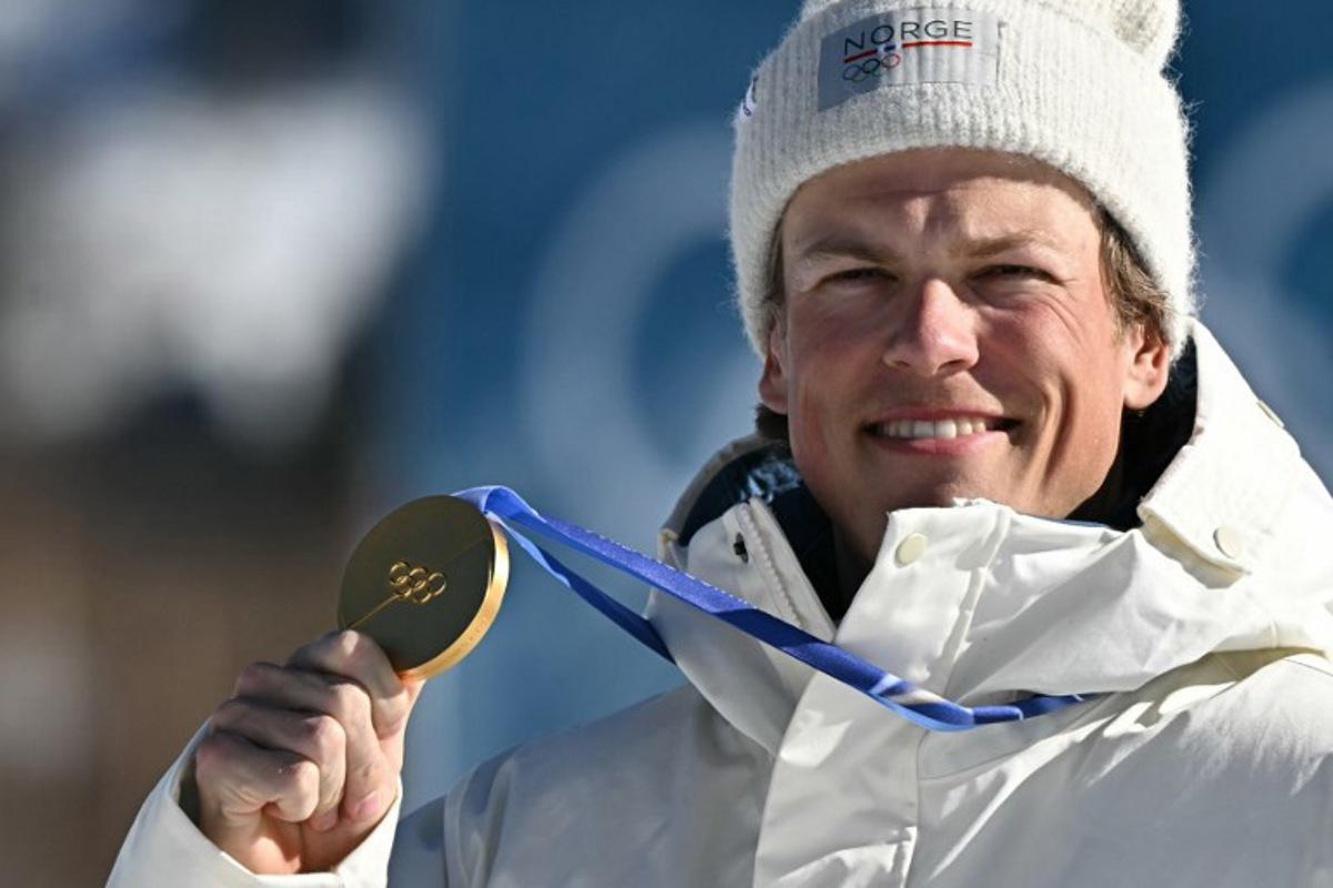 Gold medallist Norway's Johannes Hoesflot Klaebo celebrates on the podium for the men's 10km cross-country interval start free event of the Milano Cortina 2026 Winter Olympic Games at Tesero Cross-Country Skiing Stadium in Lago di Tesero (Val di Fiemme) on February 13, 2026.  Javier SORIANO / AFP