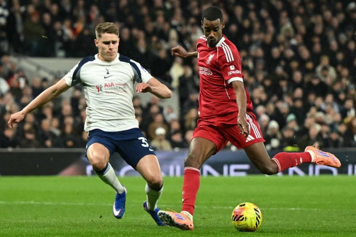Liverpool's Swedish striker #09 Alexander Isak (R) shoots to score the opening goal for 0-1 as Tottenham Hotspur's Dutch defender #37 Micky van de Ven (L) challenges during the English Premier League football match between Tottenham Hotspur and Liverpool at the Tottenham Hotspur Stadium in London, on December 20, 2025.  JUSTIN TALLIS / AFP