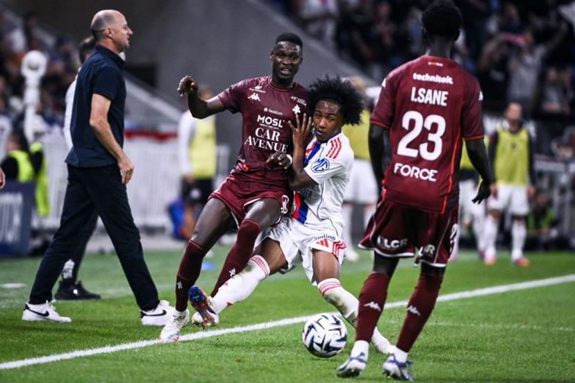 Lyon's Belgian forward #11 Malick Fofana (C) fights for the ball with Metz's Malian midfielder #08 Boubacar Traore (L) during the French L1 football match between Olympique Lyonnais (OL) and FC Metz at the Groupama Stadium in Decines-Charpieu, central-eastern France on August 23, 2025.  ARNAUD FINISTRE / AFP