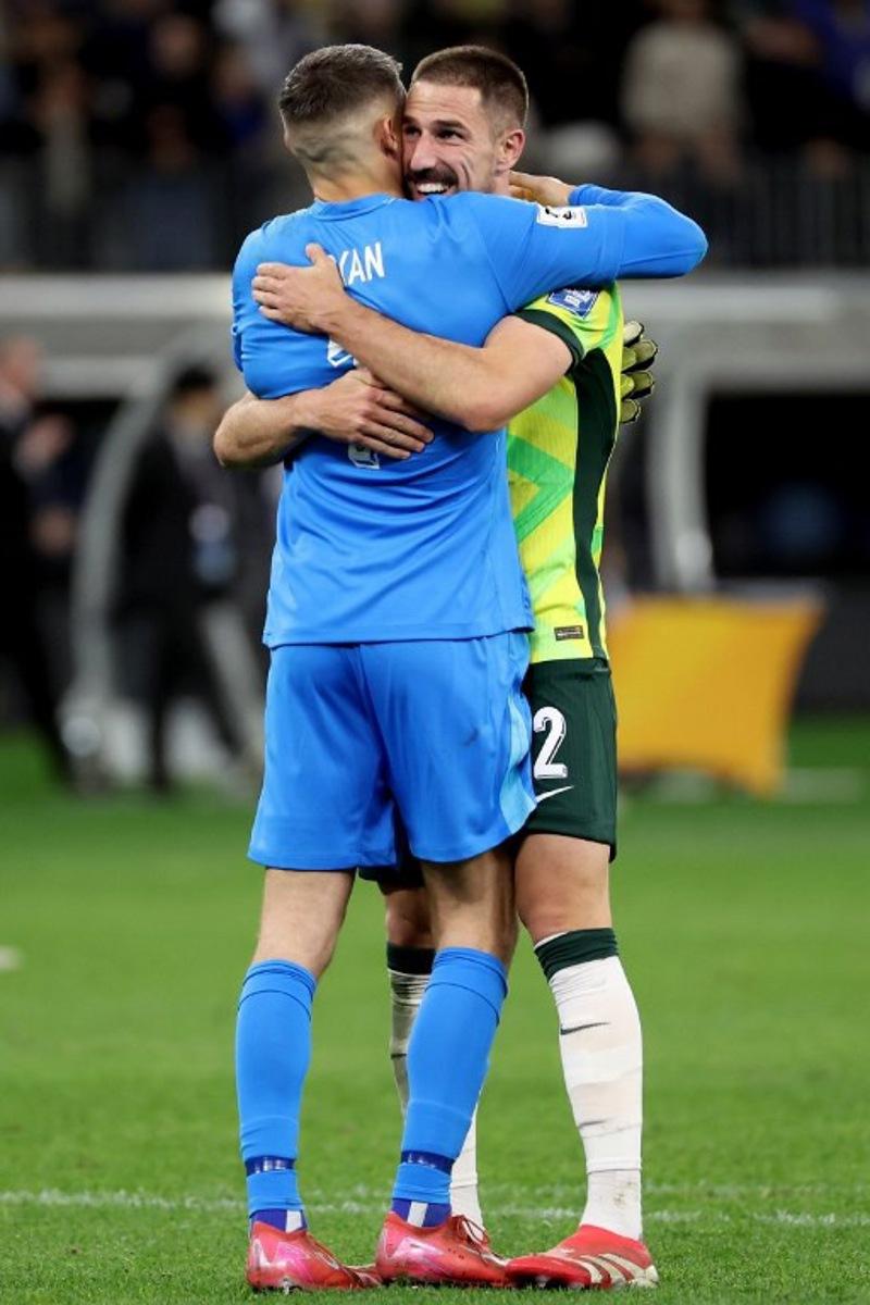 Australia's Milos Degenek (R) and goalkeeper Mathew Ryan celebrate team's victory after the 2026 FIFA World Cup Asian Qualifier football match between Australia and Japan at Optus Stadium in Perth on June 5, 2025.  COLIN MURTY / AFP
