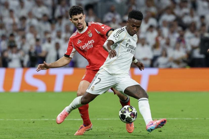 Real Madrid's Brazilian forward #07 Vinicius Junior (R) is challenged by SL Benfica's Portuguese defender #44 Tomas Araujo during the UEFA Champions League knockout round play-off second leg football match between Real Madrid CF and SL Benfica at Santiago Bernabeu Stadium in Madrid on February 25, 2026.  Pierre-Philippe MARCOU / AFP