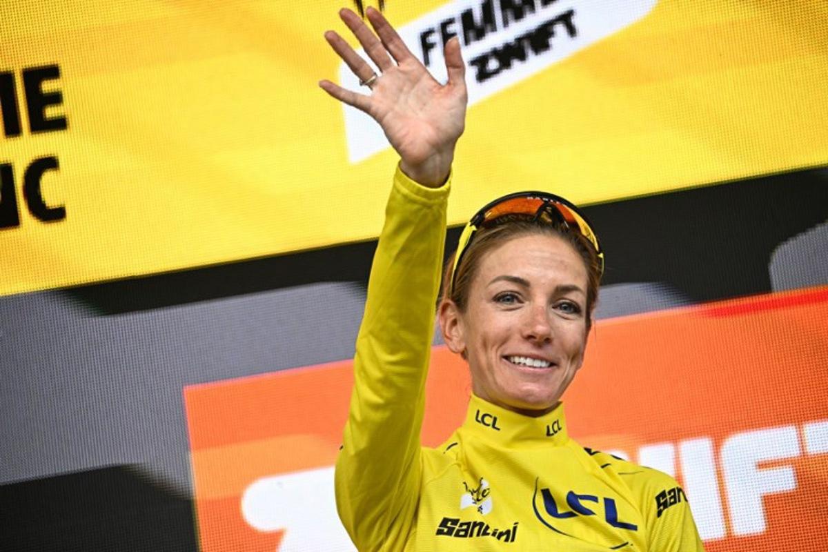 Team Visma | Lease a Bike's French rider Pauline Ferrand-Prevot celebrates with the overall leader's yellow jersey on the podium for the fourth edition of the Women's Tour de France cycling race at the end of the 9th and final stage (out of 9), 124.1 km from Praz-sur-Arly to Chatel, in Chatel eastern France, on August 3, 2025.  JULIEN DE ROSA / AFP