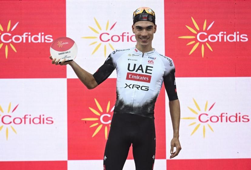 Team UAE's Spanish rider Juan Ayuso celebrates on the podium after winning the 12th stage of the Vuelta a Espana, a 144.9 km race between Laredo and Corrales de Buelna, on September 4, 2025.  ANDER GILLENEA / AFP