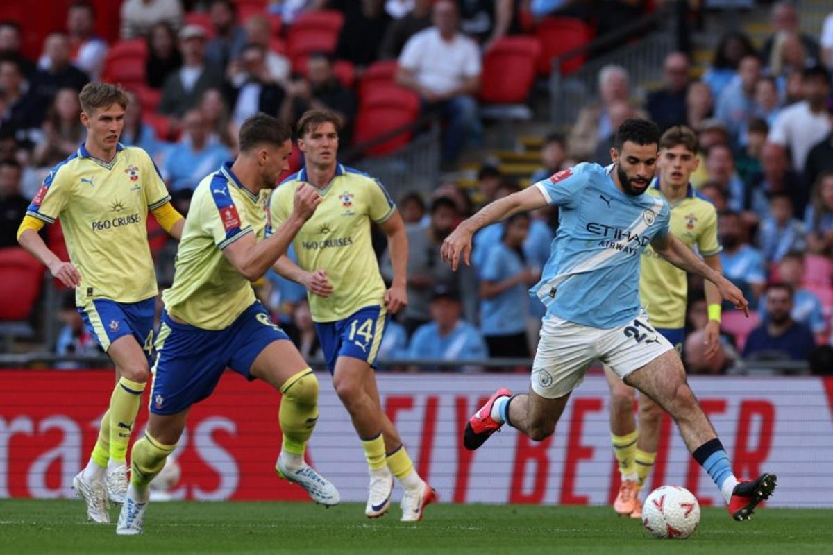 Manchester City's Algerian defender #21 Rayan Ait-Nouri (R) runs with the ball during the English FA Cup semi final football match between Manchester City and Southampton at Wembley stadium in London, on April 25, 2026.  Adrian Dennis / AFP
