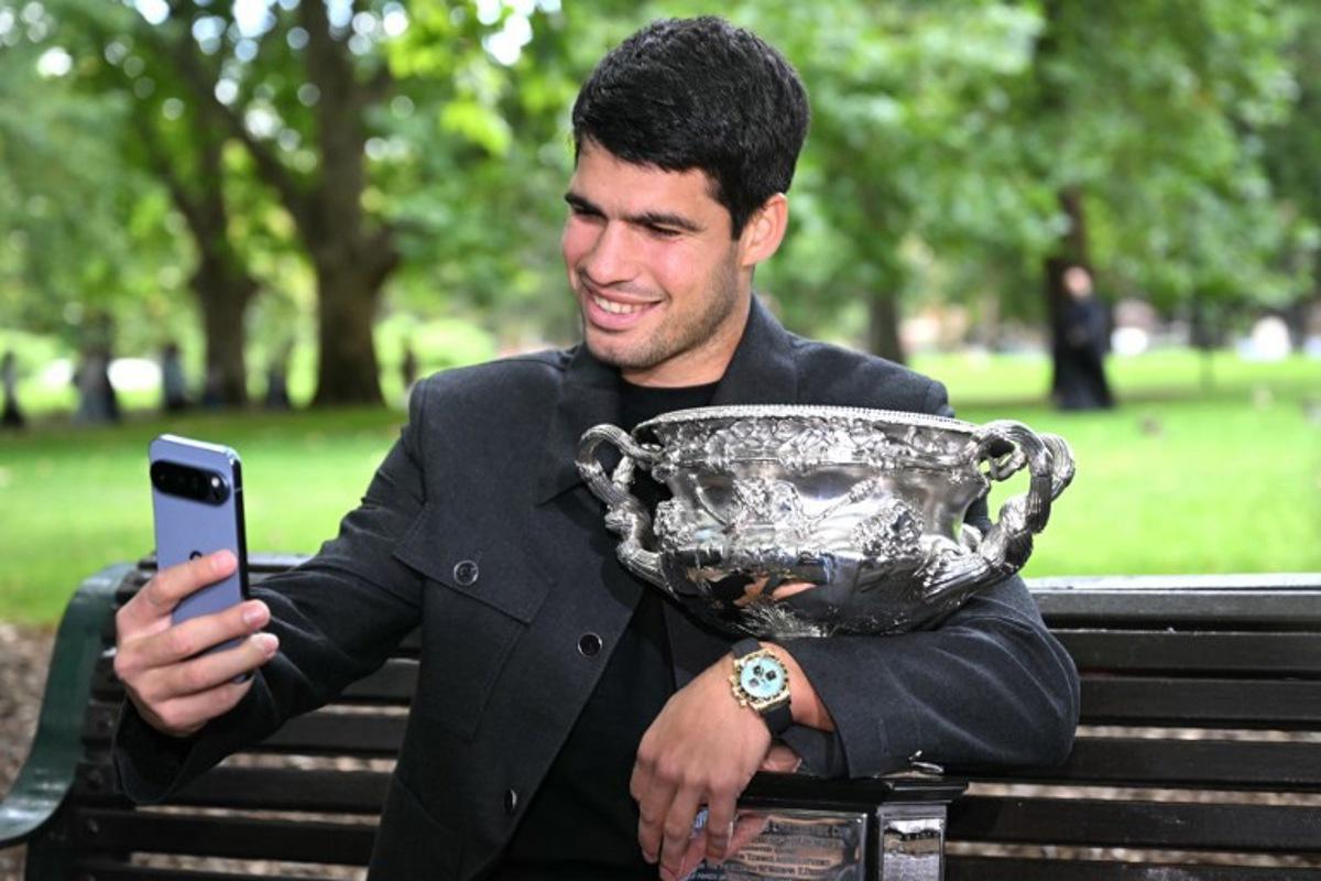 Spain's Carlos Alcaraz poses with the Norman Brookes Challenge Cup trophy at the Royal Exhibition Building following his victory against Serbia's Novak Djokovic in the men's singles final match of the Australian Open tennis tournament in Melbourne on February 2, 2026.  WILLIAM WEST / AFP