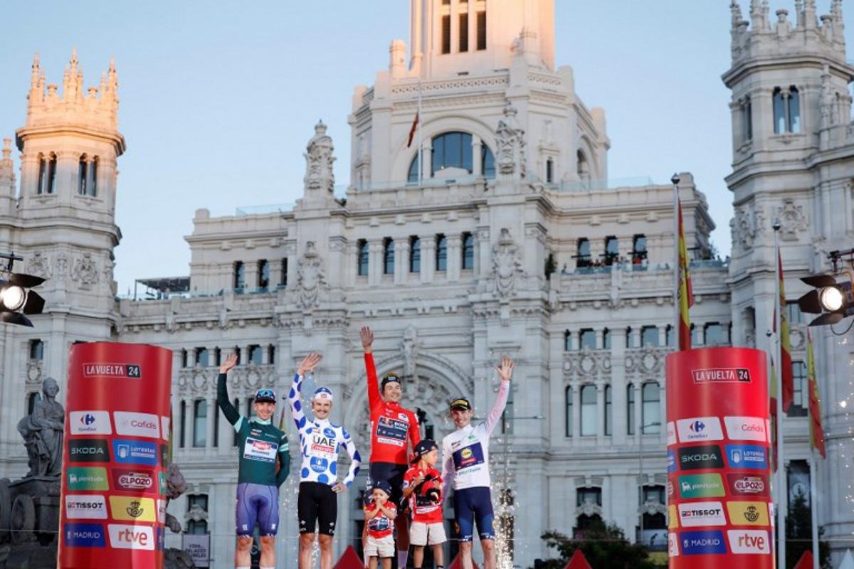 (From L) Team Alpecin's Kaden Groves, Team UAE's Jay Vine celebrates, overall leader Team Bora's Primoz Roglic and Team Lidl-Trek's Mattias Skjelmose celebrate on the podium after the last stage of the Vuelta a Espana, a 24,6 km time-trial race between Madrid and Madrid, on September 8, 2024.    OSCAR DEL POZO / AFP