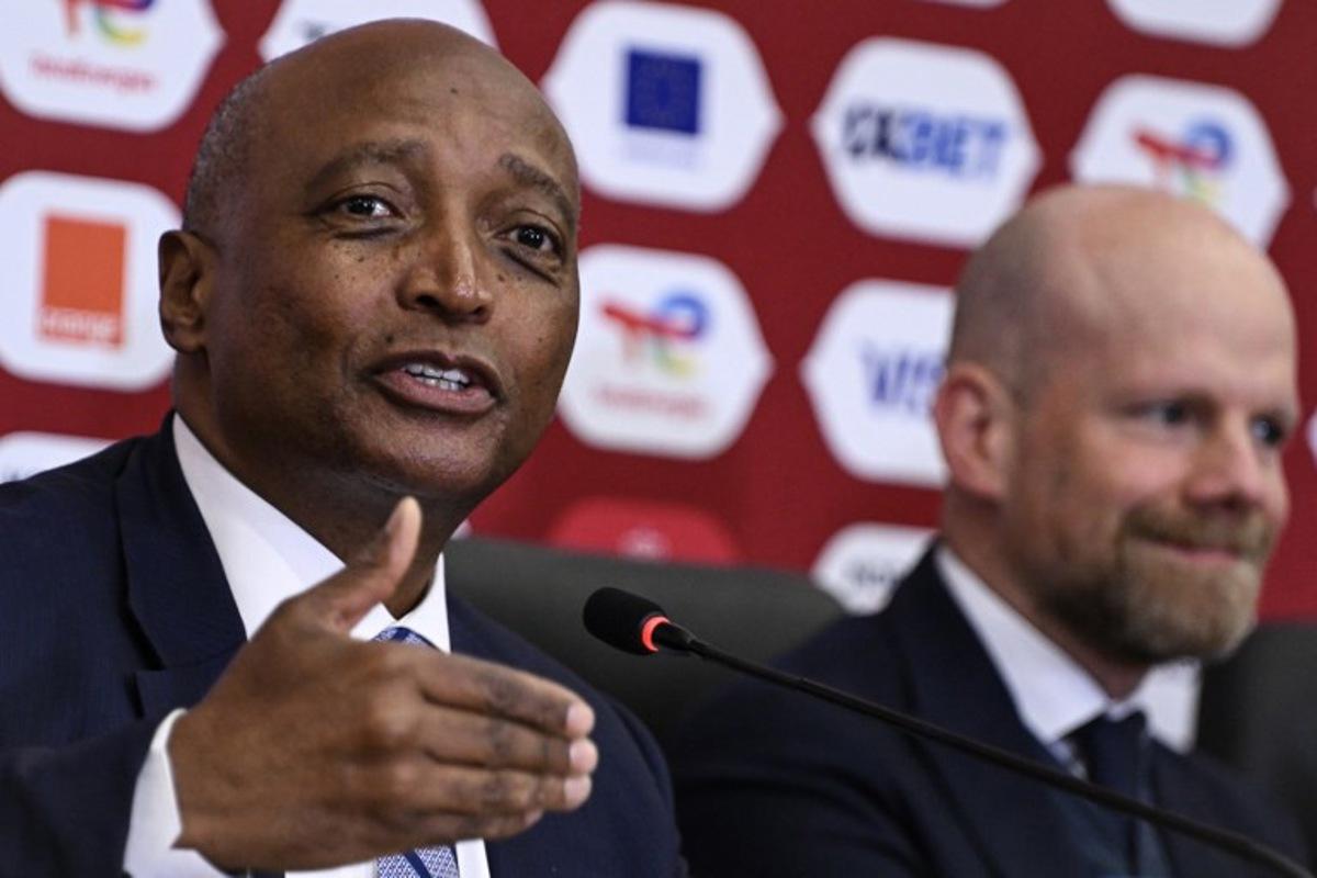 Confederation of African Football President Patrice Motsepe and Brazilian Fifa Deputy Secretary general Mattias Grafstrom (R) attend a press conference at Prince Moulay Abdellah Stadium in Rabat, Morocco on December 20, 2025, ahead of the start of the Africa Cup of Nations (CAN) football tournament. Morooco take on Comoros in the opening game on December 21. SEBASTIEN BOZON / AFP