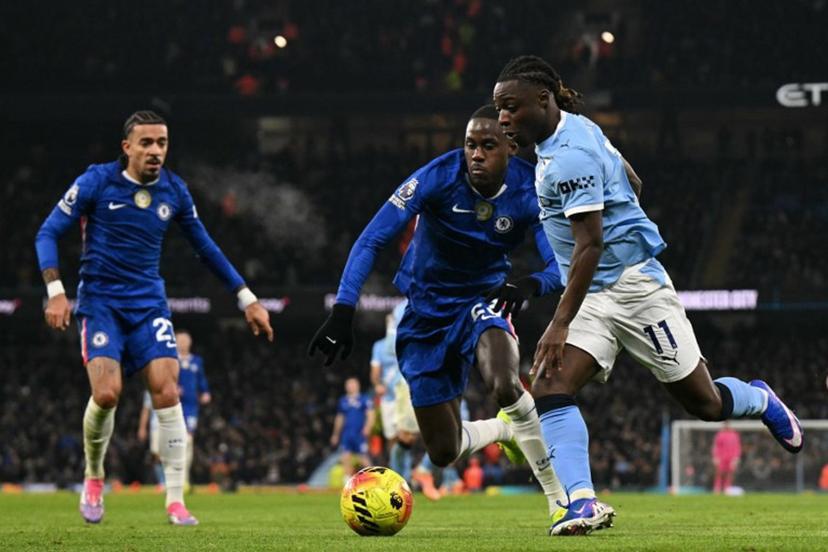 Manchester City's Belgian midfielder #11 Jeremy Doku (R) vies with Chelsea's English defender #23 Trevoh Chalobah (C) during the English Premier League football match between Manchester City and Chelsea at the Etihad Stadium in Manchester, north west England, on January 4, 2026.  Oli SCARFF / AFP
