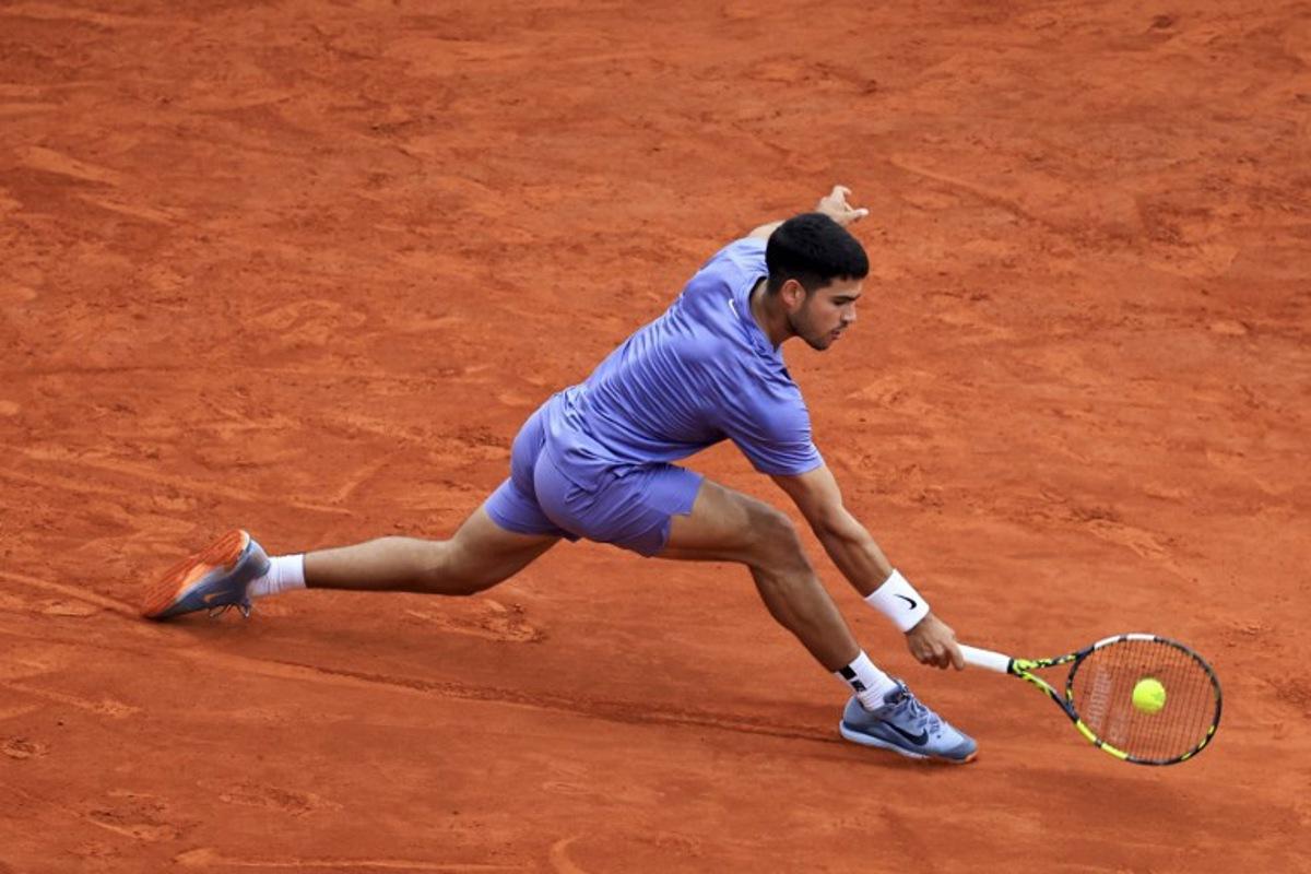 Spain's Carlos Alcaraz plays a backhand return to Spain's Alejandro Davidovich Fokina during the Monte Carlo ATP Masters Series Tournament semi-final tennis match at the Monte Carlo Country Club in Roquebrune-Cap-Martin on April 12, 2025.  Valery HACHE / AFP