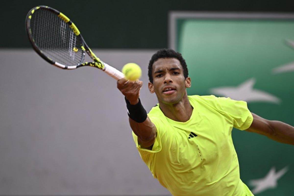 Canada's Felix Auger-Aliassime plays a backhand return to Italia's Matteo Arnaldi during their men's singles match on day 3 of the French Open tennis tournament at the Roland-Garros Complex in Paris on May 27, 2025.  JULIEN DE ROSA / AFP