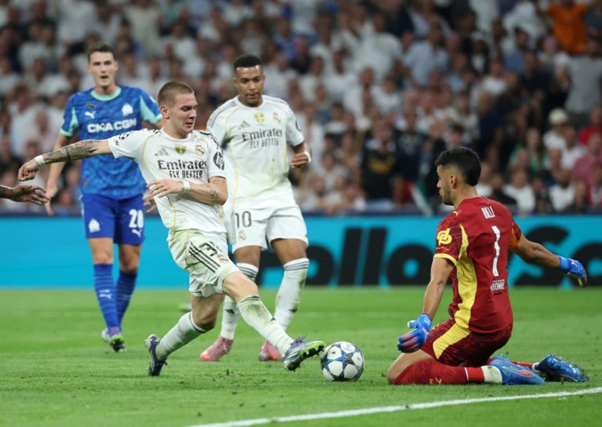 Real Madrid's Argentine forward #30 Franco Mastantuono challenges Marseille's Argentine goalkeeper #01 Geronimo Rulli during the UEFA Champions League first round day 1 football match between Real Madrid CF and Olympique de Marseille at the Santiago Bernabeu stadium in Madrid on September 16, 2025.  Pierre-Philippe MARCOU / AFP