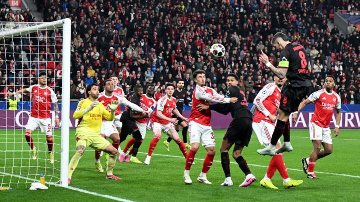 Bayer Leverkusen's German midfielder #08 Robert Andrich (2R) heads the ball to score his team's first goal during the UEFA Champions League, Last 16, first-leg football match Bayer 04 Leverkusen vs Arsenal in Leverkusen, western Germany, on March 11, 2026.    UWE KRAFT / AFP
