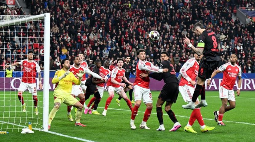 Bayer Leverkusen's German midfielder #08 Robert Andrich (2R) heads the ball to score his team's first goal during the UEFA Champions League, Last 16, first-leg football match Bayer 04 Leverkusen vs Arsenal in Leverkusen, western Germany, on March 11, 2026.    UWE KRAFT / AFP