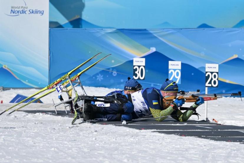 Ukraine's Maksym Yarovyi (R) and Pavlo Bal (L) compete in the men's middle distance sitting para biathlon final event on March 8, 2022 at the Zhangjiakou National Biathlon Centre, during the Beijing 2022 Winter Paralympic Games.  Mohd Rasfan / AFP