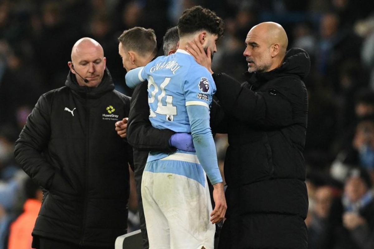 Manchester City's Croatian defender #24 Josko Gvardiol (C) speaks with Manchester City's Spanish manager Pep Guardiola after picking up an injury during the English Premier League football match between Manchester City and Chelsea at the Etihad Stadium in Manchester, north west England, on January 4, 2026.  Oli SCARFF / AFP