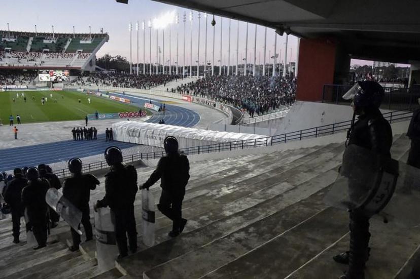 Algerian security forces stand guard during the game between national rival football clubs at the 5 July stadium in the outskirts of central Algiers on March 14, 2019. The Algiers derby on March 14 between the capital's rival football clubs, USM Alger and MC Alger, had a low attendance following a call for fans to stay away from the rescheduled match over fears of potential trouble.  RYAD KRAMDI / AFP