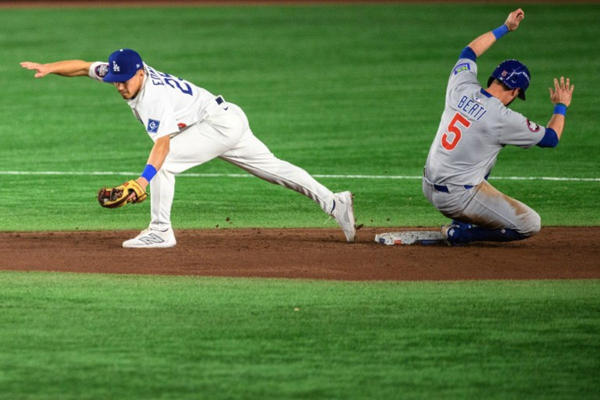 LA Dodgers' Tommy Edman (L) catches the ball as Chicago Cubs' Jon Berti slides to second base during the baseball game between the Los Angeles Dodgers and Chicago Cubs in the MLB Tokyo Series at the Tokyo Dome in Tokyo on March 19, 2025.  Philip FONG / AFP
