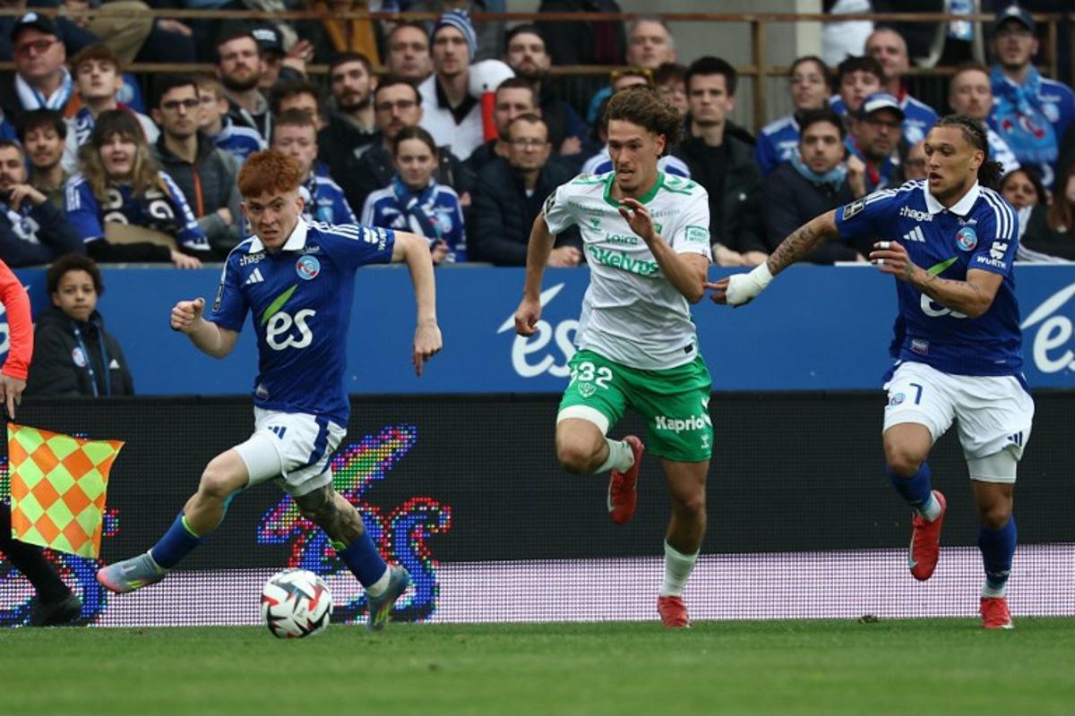 Saint Etienne's Belgian forward #32 Lucas Stassin fights for the ball with Strasbourg's Argentinian defender #32 Valentin Barco and Strasbourg's Portuguese forward #07 Diego Moreira during the French L1 football match between RC Strasbourg Alsace and AS Saint-Etienne at Stade de la Meinau in Strasbourg, north-eastern France on April 26, 2025.   Frederick FLORIN / AFP