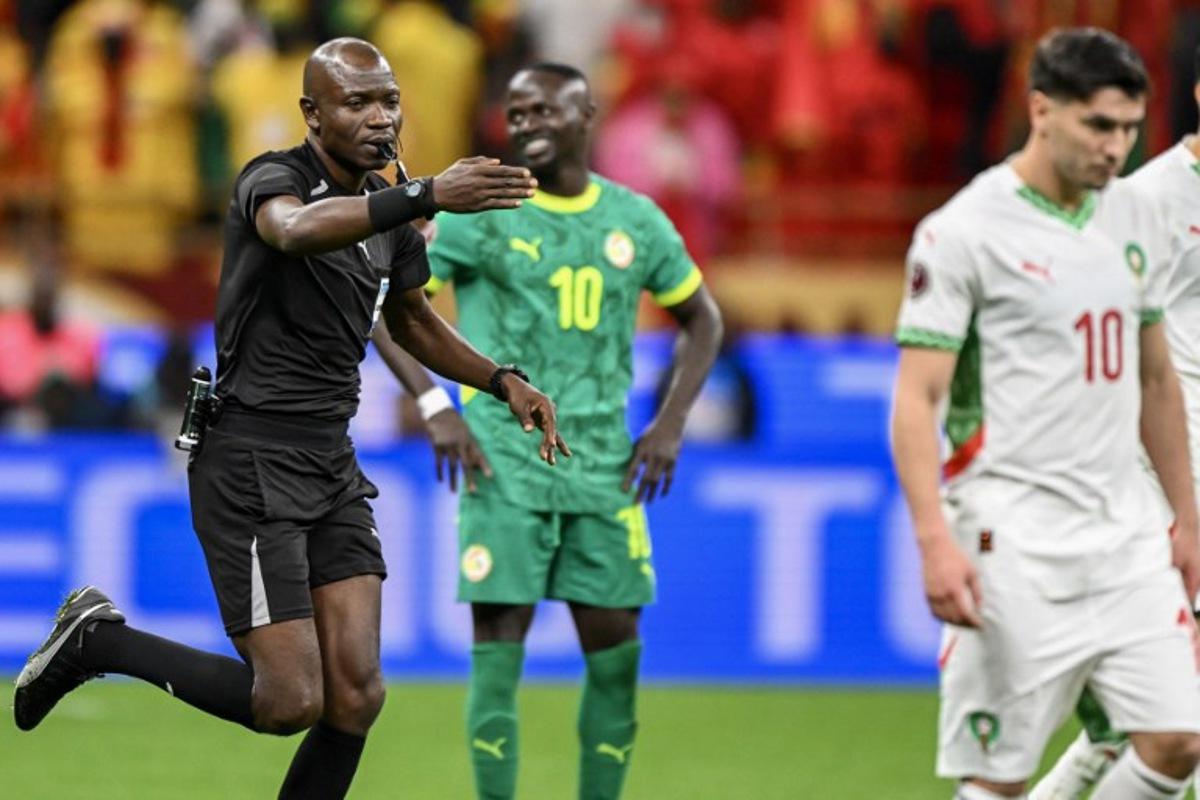 Congolese referee Jean-Jacques Ndala Ngambo whistles a penalty as Senegal's forward #10 Sadio Mane and Morocco's forward #10 Brahim Diaz react during the Africa Cup of Nations (CAN) final football match between Senegal and Morocco at the Prince Moulay Abdellah Stadium in Rabat on January 18, 2026.   SEBASTIEN BOZON / AFP