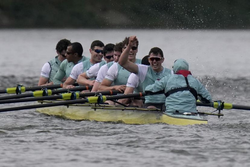 (R-L) Cambridge's Cox, Sammy Houdagui and rowers Freddy Breuer, Will Klipstine, Lexi McClean, Gabriel Obholzer, Patrick Wild, Kyle Fram, French president, Noam Mouelle, and Simon Hatcher celebrate winning the 171th men's boat race between Oxford University and Cambridge University on the River Thames in London on April 4, 2026.   CARLOS JASSO / AFP