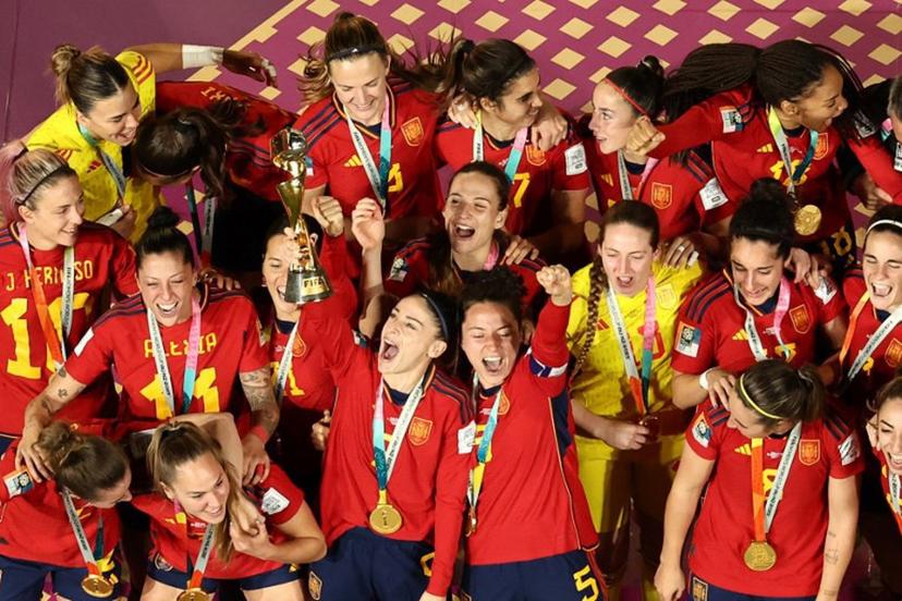 Spain's players celebrate with the trophy on the podium after winning the Australia and New Zealand 2023 Women's World Cup final football match between Spain and England at Stadium Australia in Sydney on August 20, 2023.  DAVID GRAY / AFP