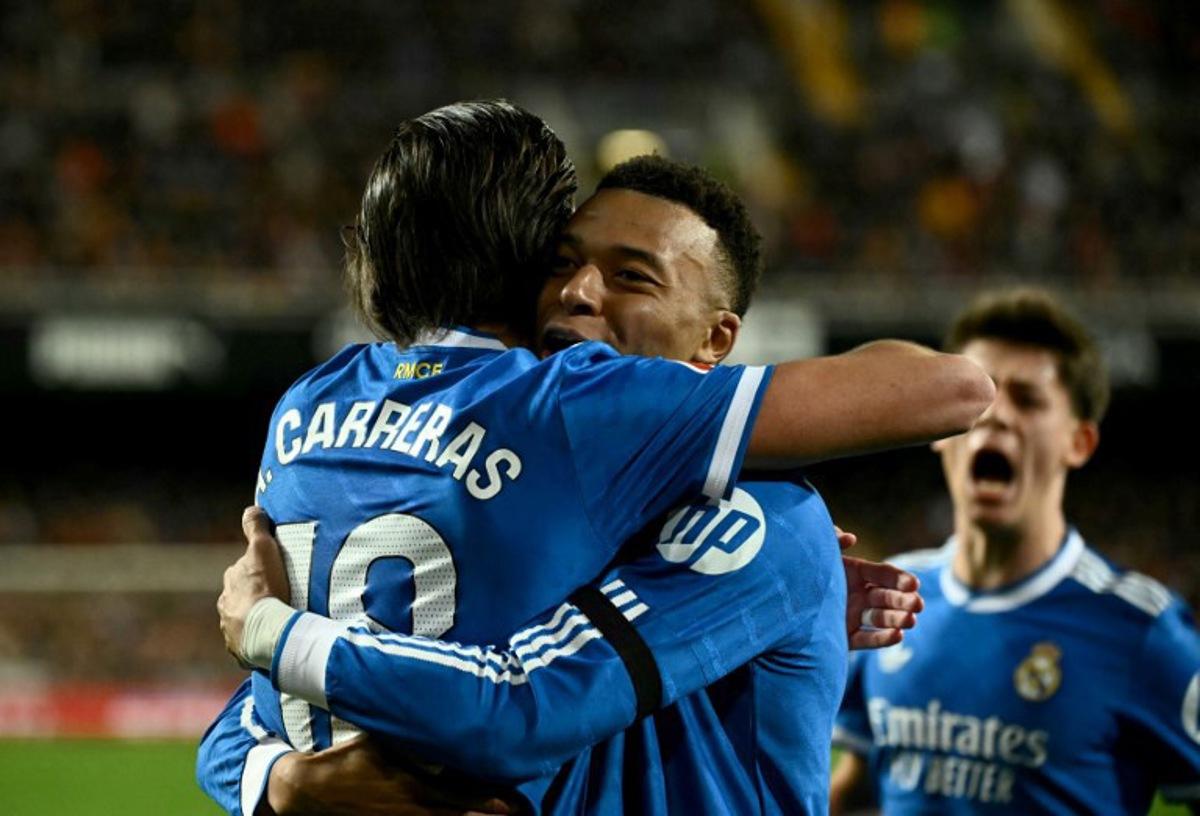 Real Madrid's Spanish defender #18 Alvaro Carreras celebrates with Real Madrid's French forward #10 Kylian Mbappe scoring his team's first goal during the Spanish league football match between Valencia CF and Real Madrid CF at Mestalla Stadium in Valencia on February 8, 2026.  JOSE JORDAN / AFP