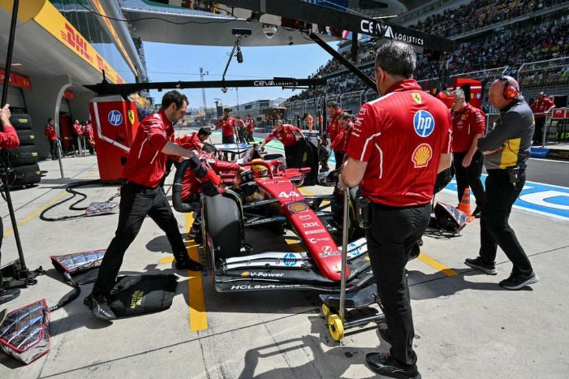 Mechanics work on the car of Ferrari's British driver Lewis Hamilton in the pits during the first practice session of the Formula One Chinese Grand Prix at the Shanghai International Circuit in Shanghai on March 21, 2025.  HECTOR RETAMAL / AFP