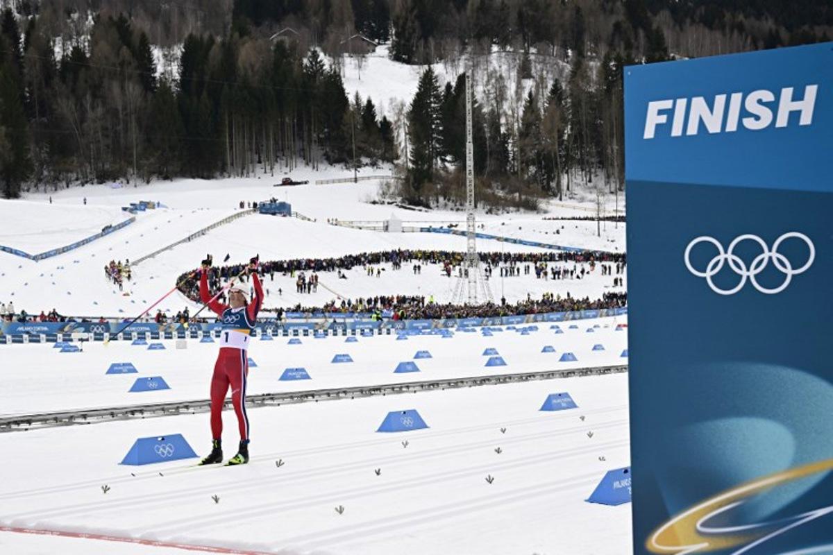 Norway's Johannes Hoesflot Klaebo celebrates as he crosses the finish line to win gold in the men's cross country 50km mass start final event of the Milano Cortina 2026 Winter Olympic Games at Tesero Cross-Country Skiing Stadium in Lago di Tesero (Val di Fiemme) on February 21, 2026.  Tobias SCHWARZ / AFP