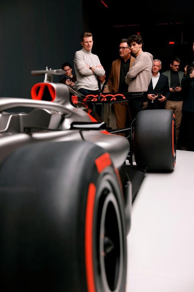 Massimo Frascella (C), Chief Creative Officer at AUDI AG, together with Kick Sauber's German driver Nico Hulkenberg (L) and Kick Sauber's Brazilian driver Gabriel Bortoleto (R) unveils the F1 car of the Audi F1 factory team set to compete in the Formula One starting in the 2026 season in Munich, southern Germany on November 12, 2025.  Alexandra BEIER / AFP
