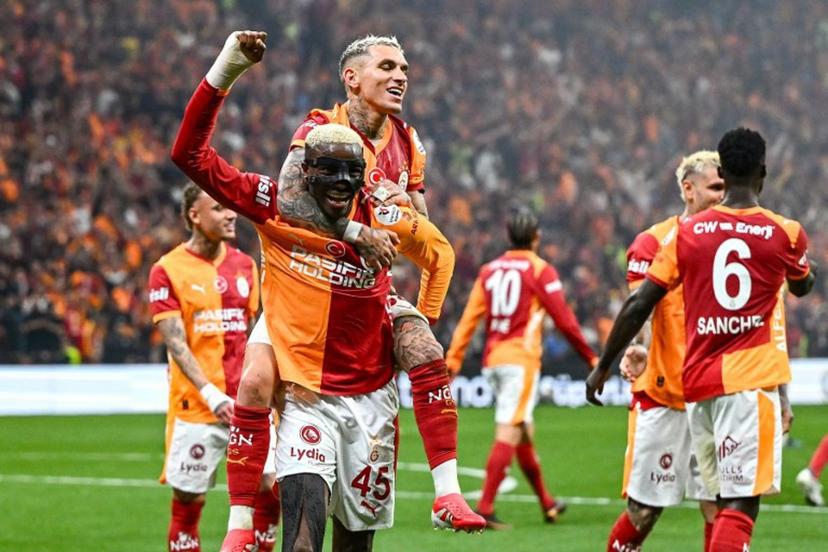 Galatasaray's Uruguayan midfielder #34 Lucas Torreira (2nd L) celebrates with Galatasaray's Nigerian forward #45 Victor Osimhen (L) after scoring his team's third goal   during the Turkish Super lig football match between Fenerbahce and Galatasaray at the Rams Park stadium in Istanbul, on April 26, 2026.  Yasin AKGUL / AFP