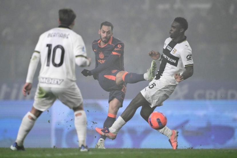 Inter Milan's Turkish midfielder #20 Hakan Calhanoglu kicks the ball next to Parma's Belgian midfielder #16 Mandela Keita during the Italian Serie A football match between Parma and Inter Milan at the Ennio Tardini stadium in Parma on January 7, 2026.  Marco BERTORELLO / AFP