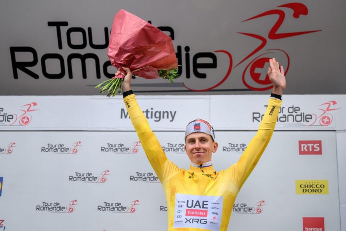UAE Team Emirates-XRG's Slovenian rider Tadej Pogacar wearing the overall leader's yellow jersey celebrates on the podium of the first stage of the Tour of Romandie UCI cycling World tour, a 171.2 km loop from Martigny-Ville to Martigny-Ville, in Martigny, on April 29, 2026.  Fabrice COFFRINI / AFP