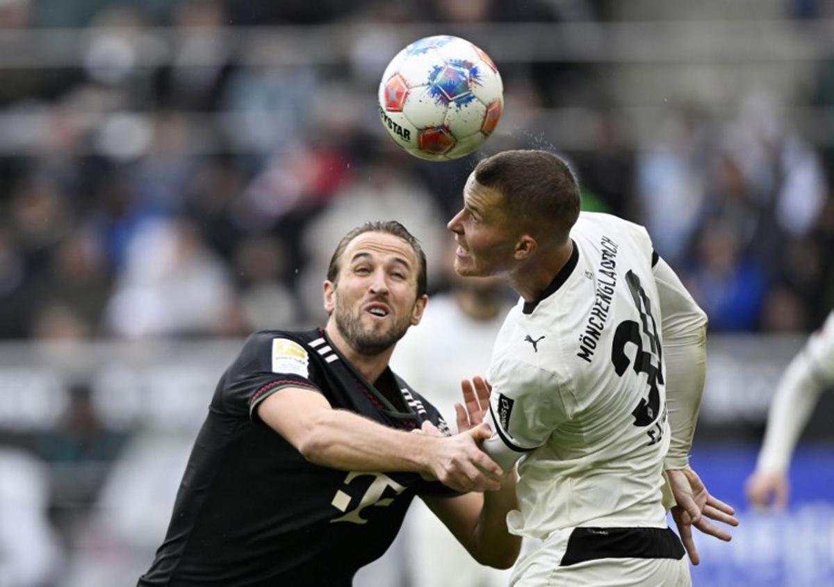 Moenchengladbach's German-Ghanaian midfielder #34 Charles Herrmann (R) and Bayern Munich's English forward #09 Harry Kane vie for the ball during the German first division Bundesliga football match between Borussia Moenchengladbach and FC Bayern Munich in Moenchengladbach, western Germany on October 25, 2025.  INA FASSBENDER / AFP