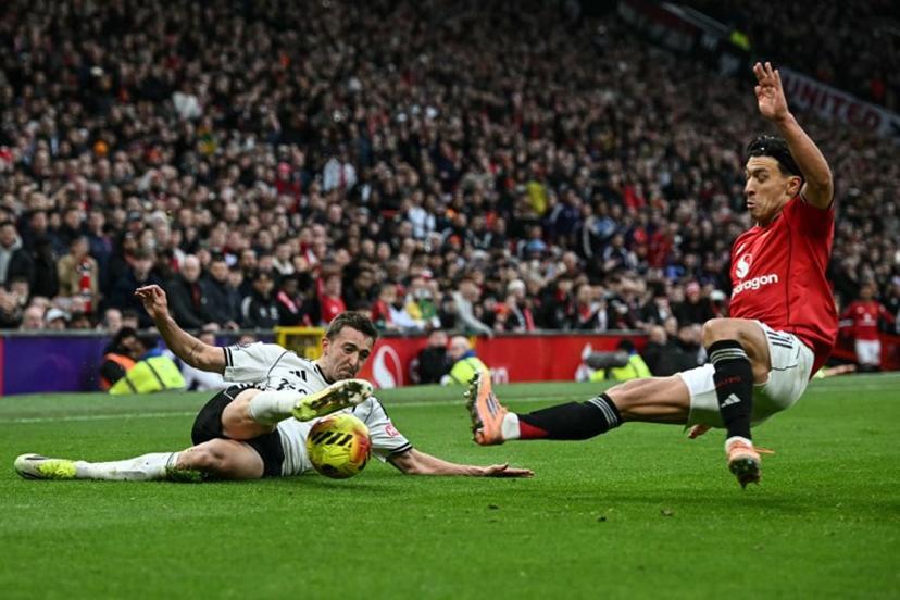 Fulham's Belgian defender #21 Timothy Castagne (L) clashes with Manchester United's Argentinian defender #06 Lisandro Martinez (R) during the English Premier League football match between Manchester United and Fulham at Old Trafford in Manchester, north west England, on February 1, 2026.  Paul ELLIS / AFP