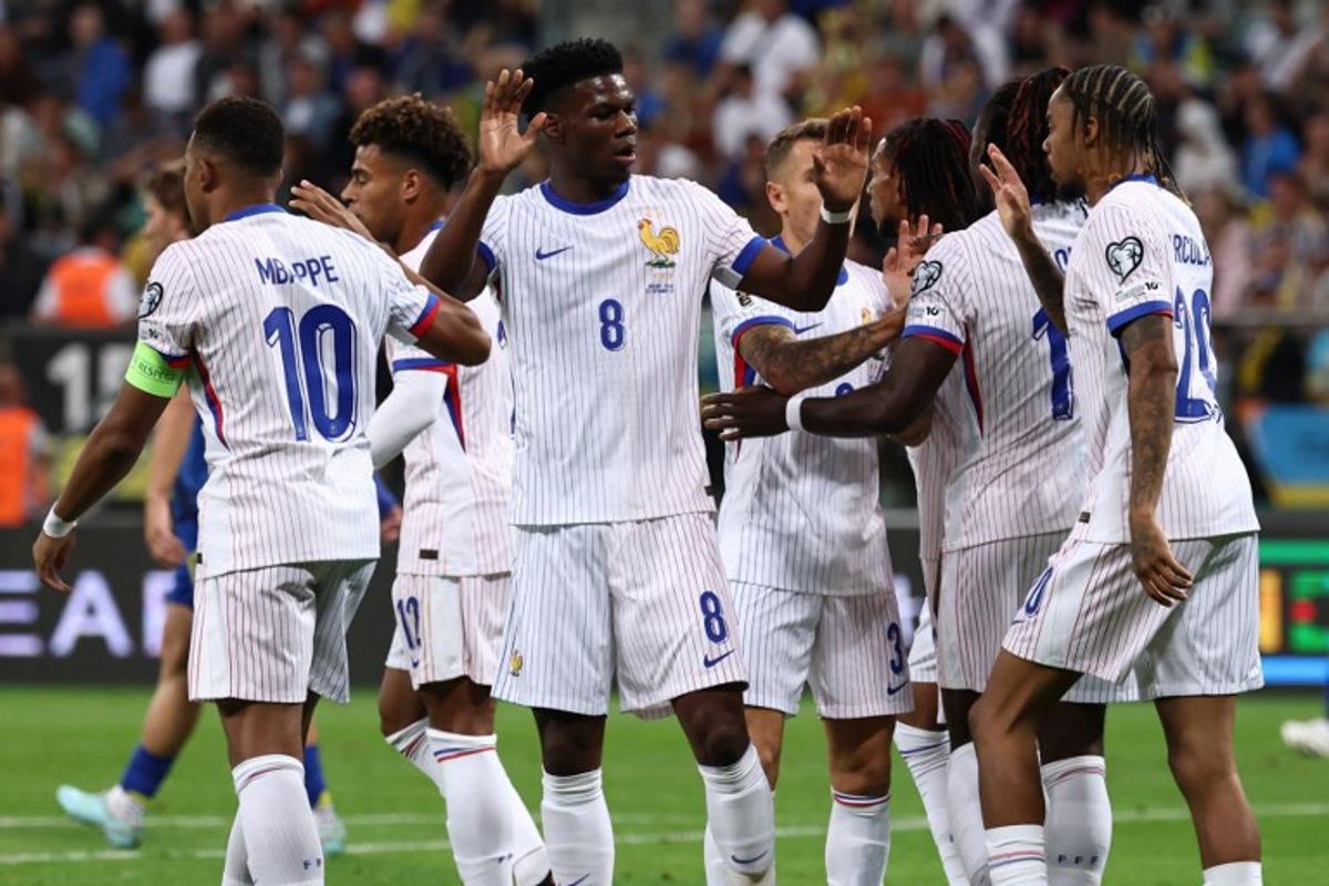 France's forward #11 Michael Olise celebrates with his team mates after scoring his team's first goal during the 2026 World Cup qualifiers Europe zone group D football match between Ukraine and France, on September 5, 2025 in Wroclaw, Poland.  FRANCK FIFE / AFP