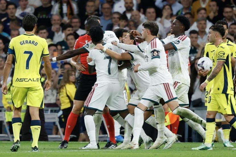 Real Madrid's Brazilian forward #07 Vinicius Junior (C) is restrained by teammates as he argues with referee Isidro Escuderos after receiving a red card during the Spanish league football match between Real Madrid CF and Villarreal CF at the Santiago Bernabeu Stadium in Madrid on October 10, 2026.  Oscar DEL POZO / AFP